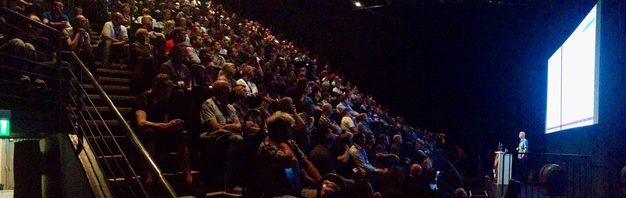 A speaker giving a technical presentation to a large crowd at NDC Oslo